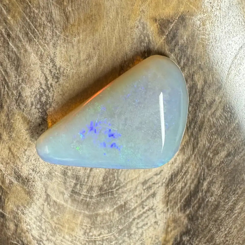 Polished Lightning Ridge Opal gemstone showcasing blue and green flash interior brilliance
