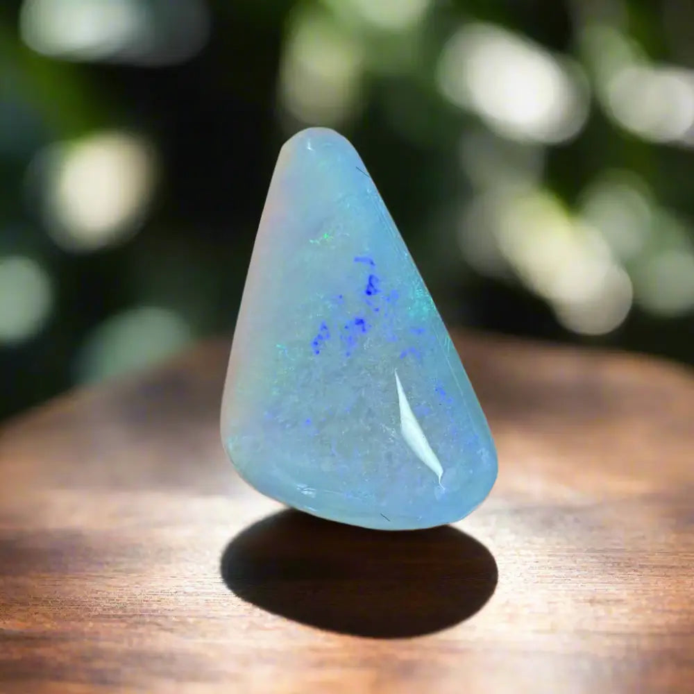 Polished light blue Lightning Ridge Opal with green and blue inclusions in a hand-cut style
