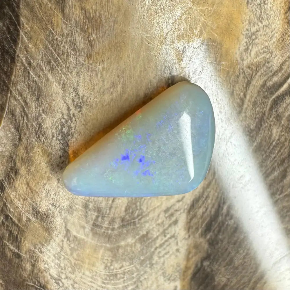 Hand-cut solid Lightning Ridge opal gemstone displaying vivid iridescent colors and play of light