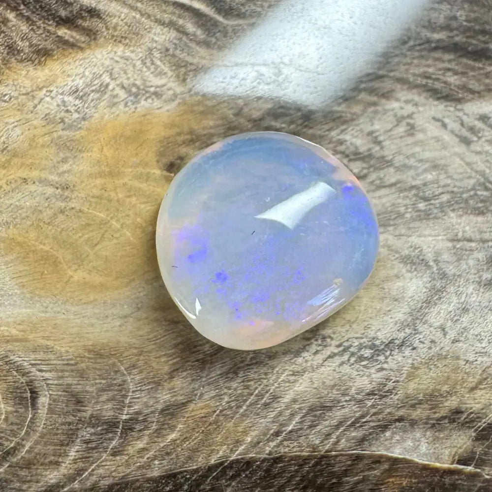 Translucent Lightning Ridge Opal cabochon showcasing vibrant blue play-of-color, 4.7 carats