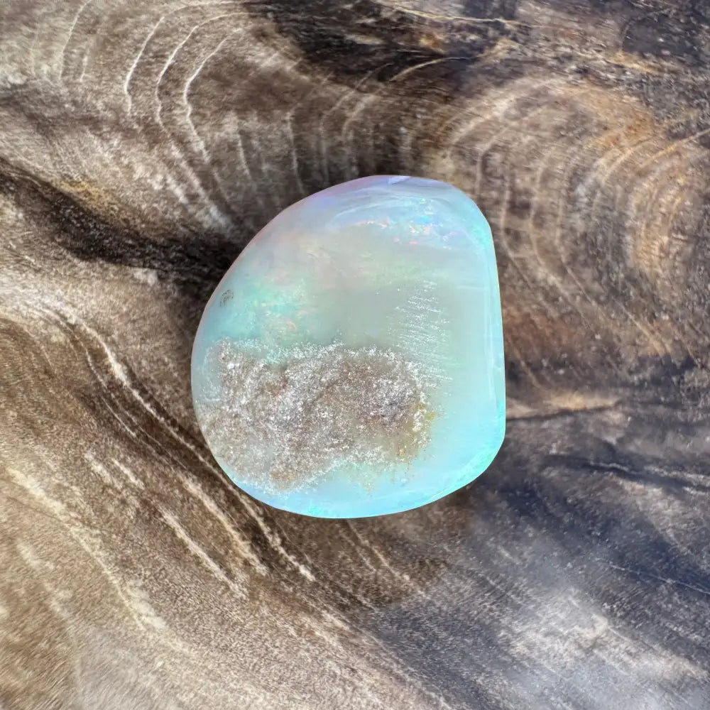 Polished iridescent blue Lightning Ridge Opal showcasing vibrant play of colors in a 7.3carat hand-cut specimen
