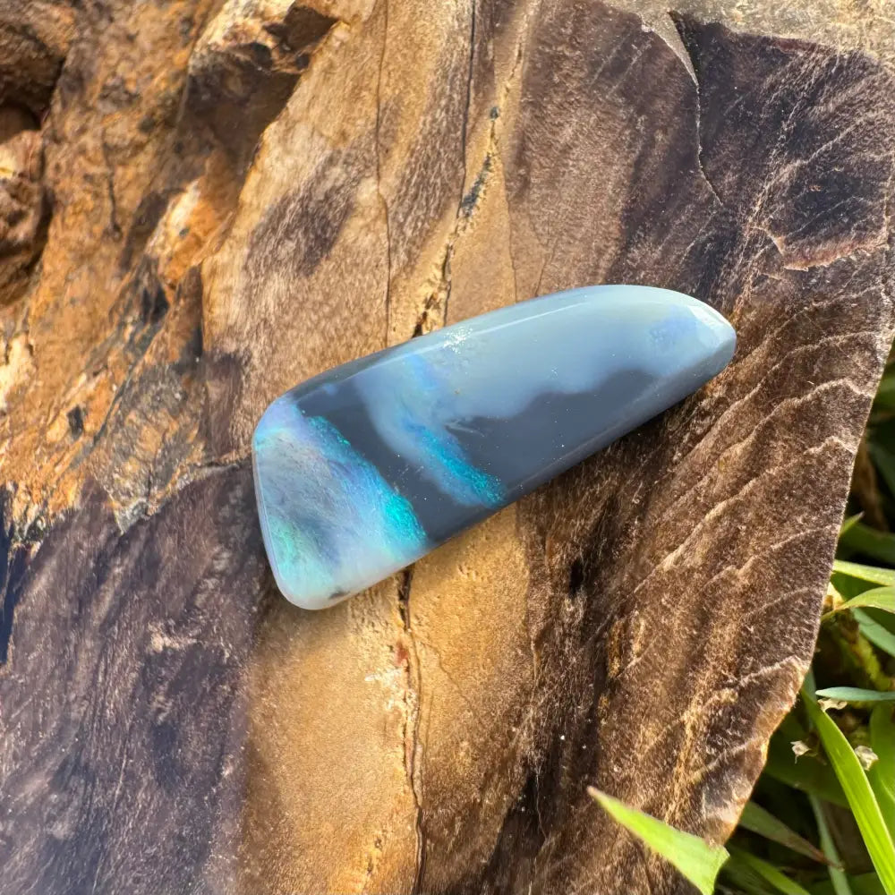 Polished Lightning Ridge semi black opal cabochon with blue and gray hues for jewelry craft