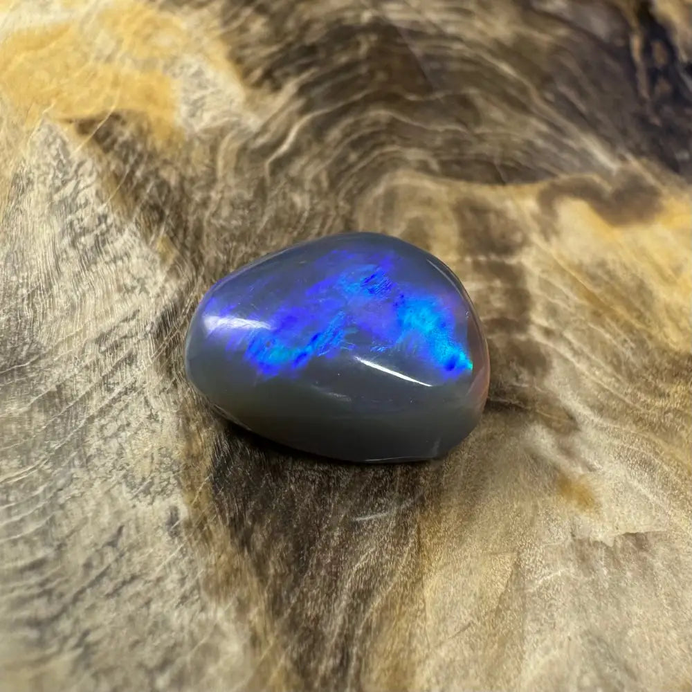 Polished gray lightning ridge semi black opal with blue iridescence and 5.4 carats