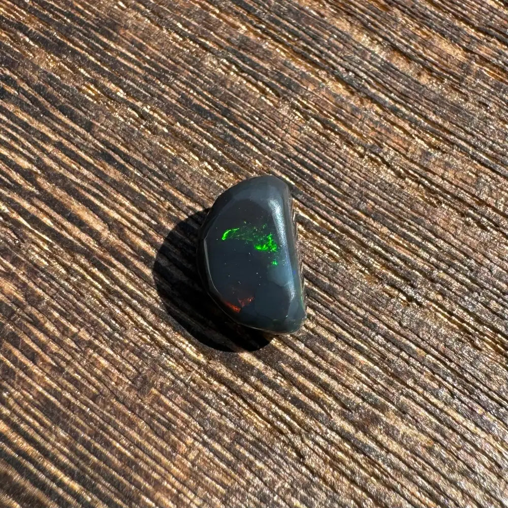 Polished Lightning Ridge Black Opal with green and red flashes in a 1.4 carat solid handcrafted cut
