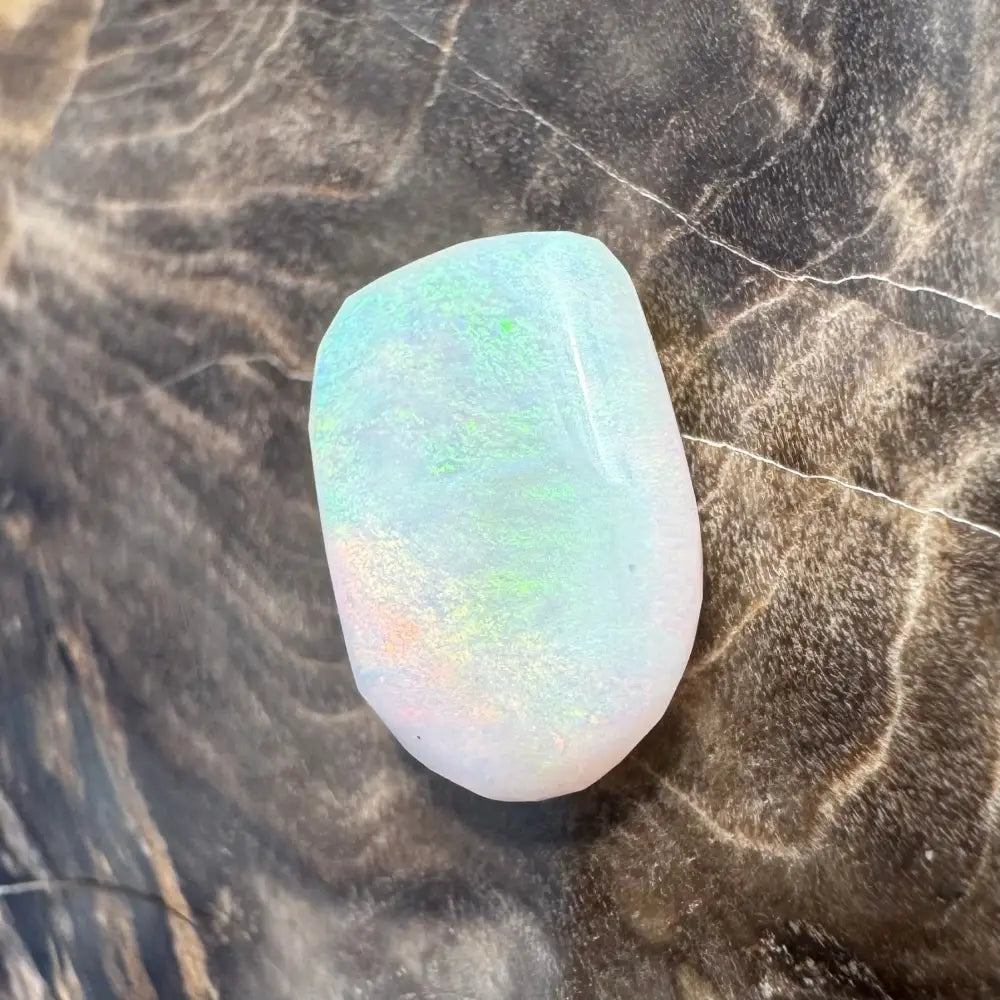 Ir idescent Lightning Ridge Opal gemstone displaying vibrant color play in a 1.3carat hand-cut piece