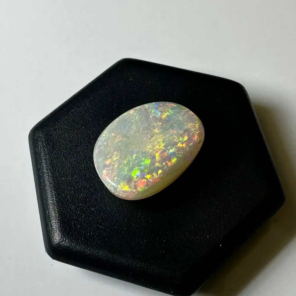 Iridescent oval opal from Lightning Ridge showcasing vibrant color play in a 2.4 carat solid hand-cut gemstone