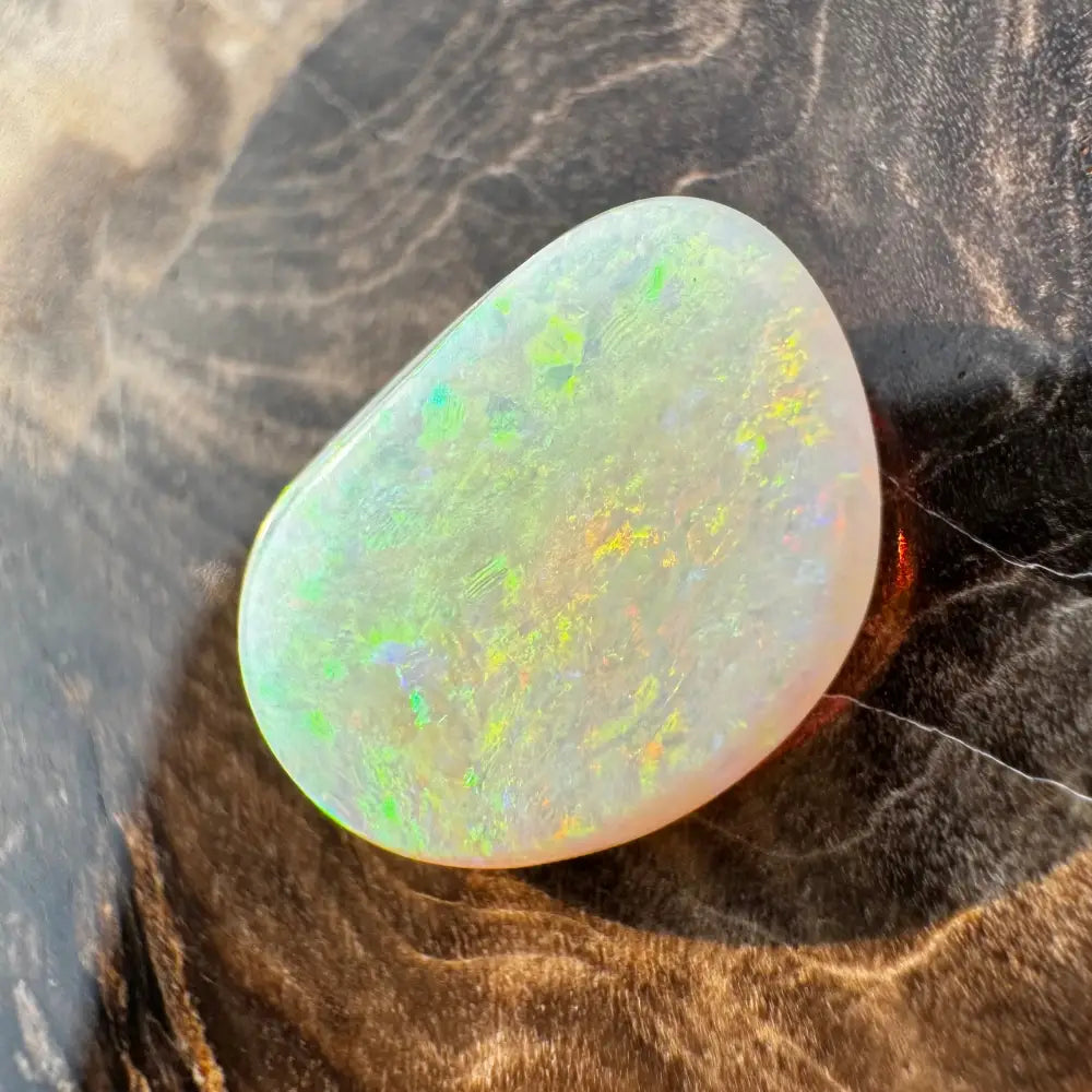 Iridescent Lightning Ridge Opal gemstone displaying vibrant colors in a 2.4carat solid hand-cut form