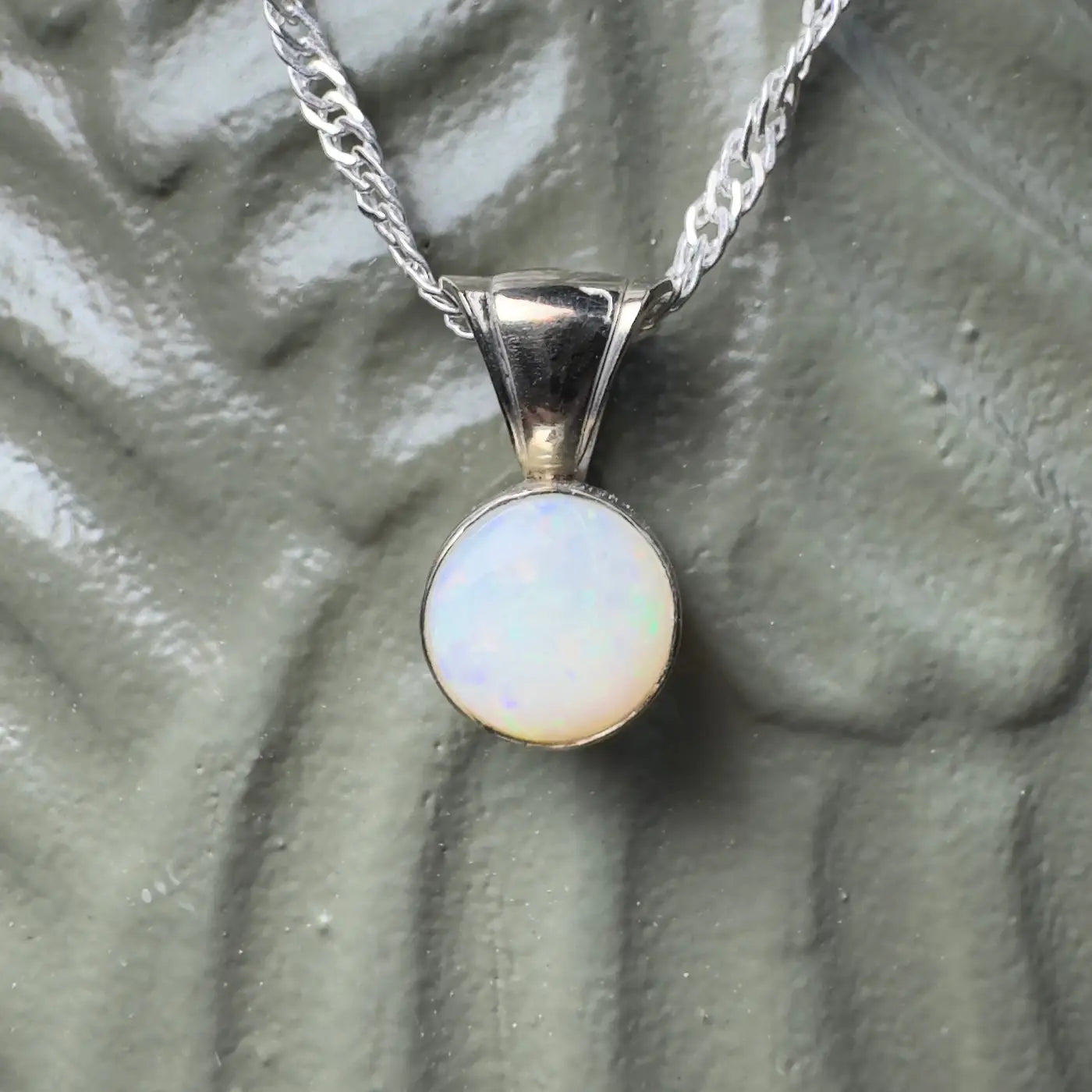 Silver necklace with a round Coober Pedy opal pendant in handcrafted white gold style