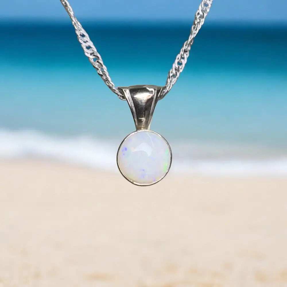 Silver chain necklace with opal pendant.