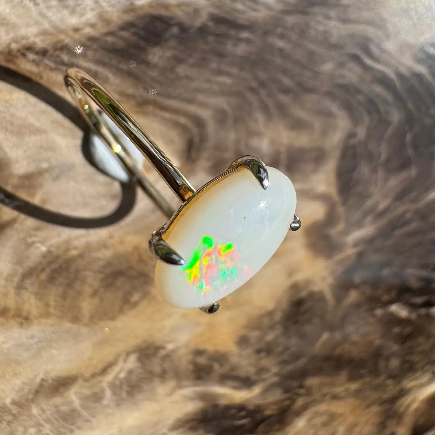 Opal ring with silver band shown in Rolling Colours of Coober handcrafted gold ring