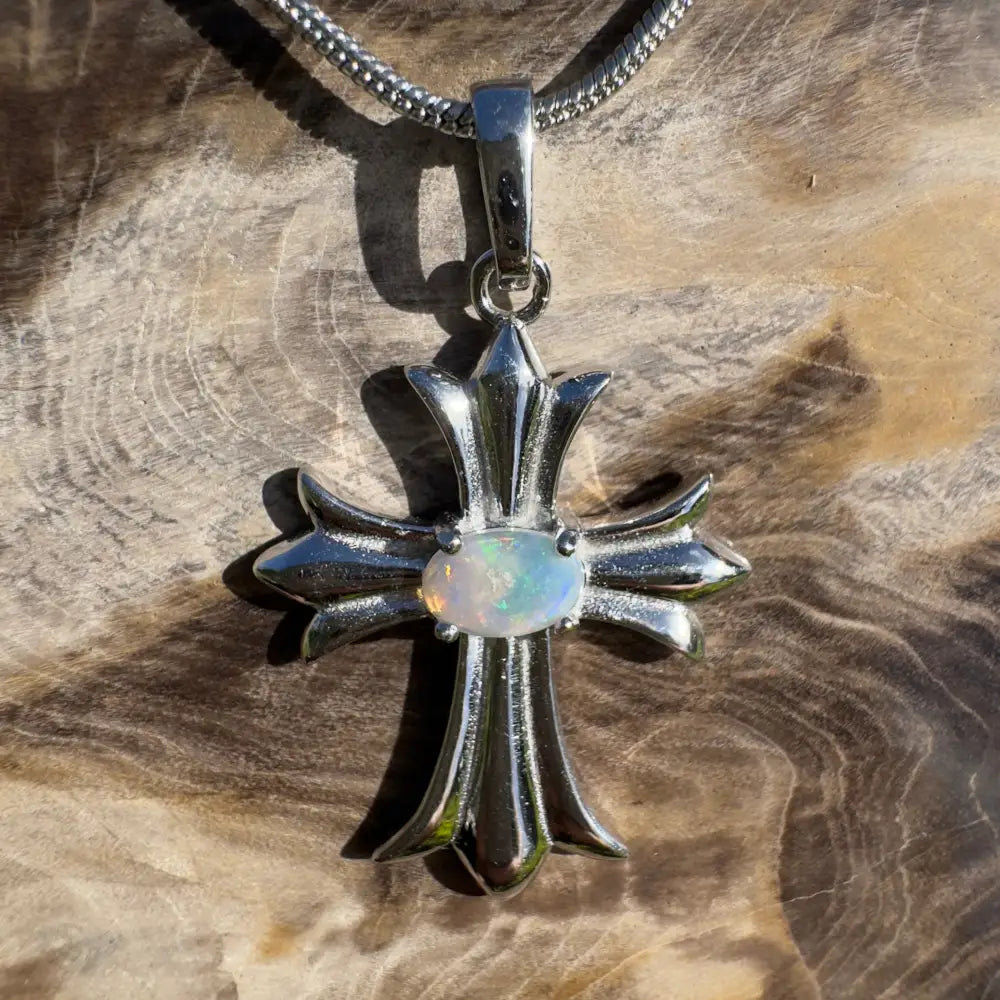 Silver cross pendant with opal center.