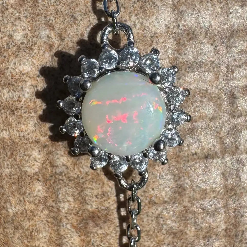 Opal pendant with cubic zirconia halo.