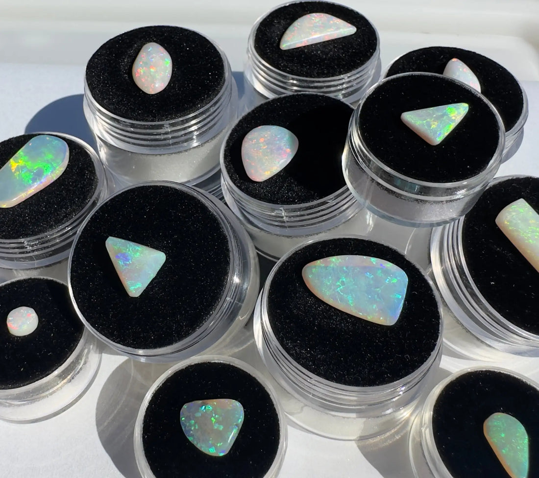 Collection of vibrant Australian opals in clear containers for jewelry and collection showcases