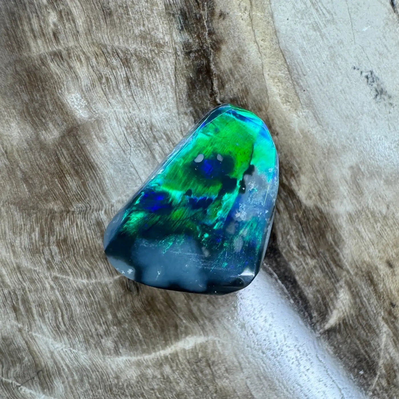 Iridescent green and blue lightning Ridge black opal gemstone for jewelry display