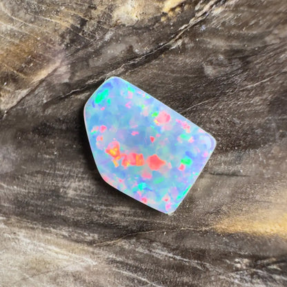 Irregularly shaped opal with colorful flashes.