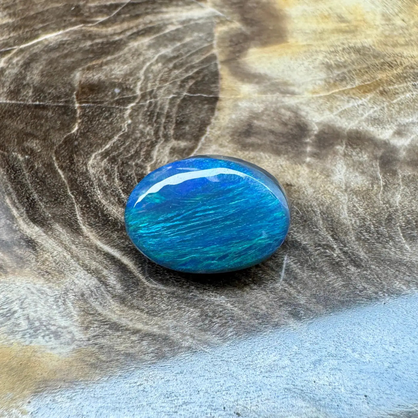 Iridescent blue-green opal cabochon from Lightning Ridge in a 1.4ct hand-cut semi black opal pendant