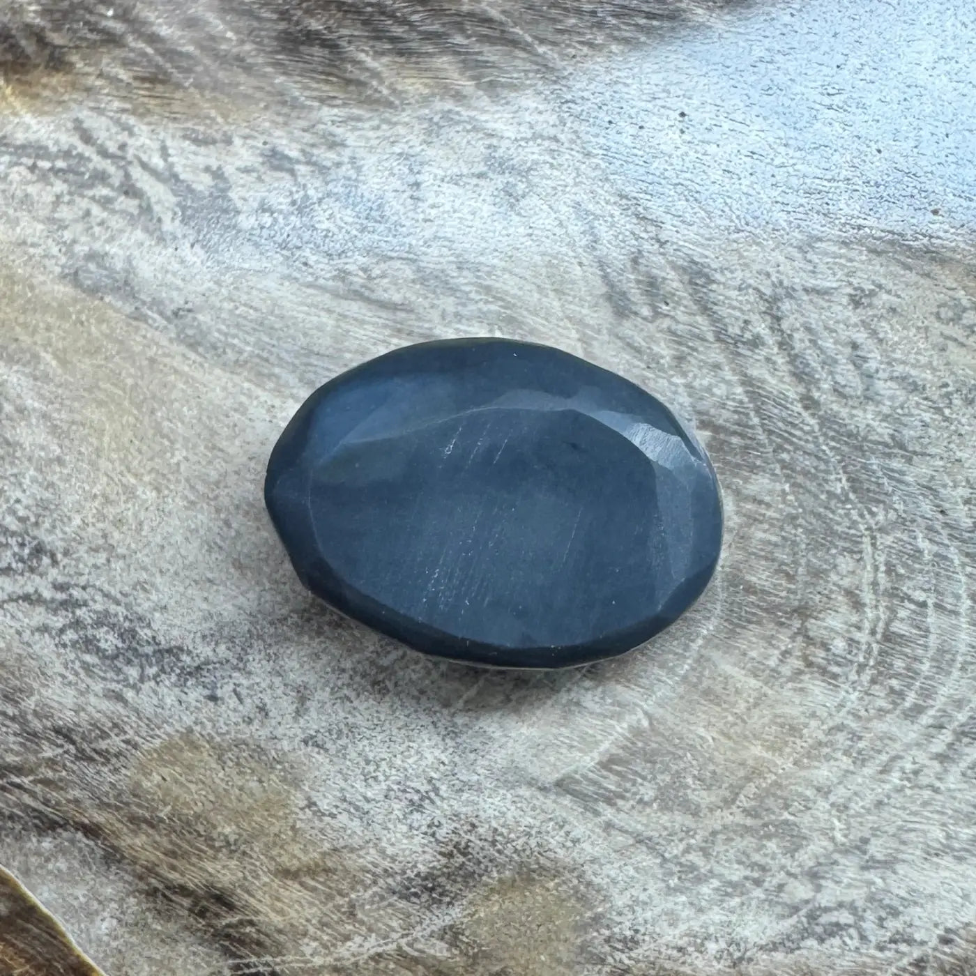Oval faceted dark gemstone in 1.4ct Hand-Cut Solid Lightning Ridge Semi Black Opal