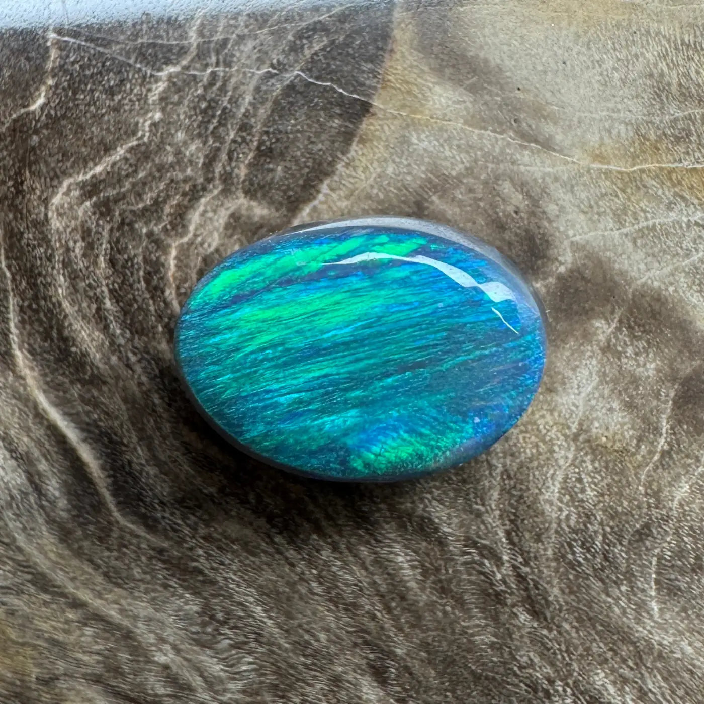 Oval-shaped blue-green opal in a 1.4ct hand-cut Lightning Ridge semi-black opal jewelry piece