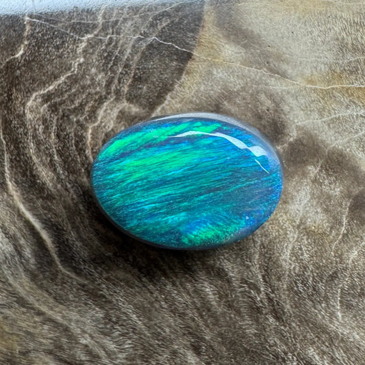 Oval-shaped blue-green opal in a 1.4ct hand-cut Lightning Ridge semi-black opal jewelry piece
