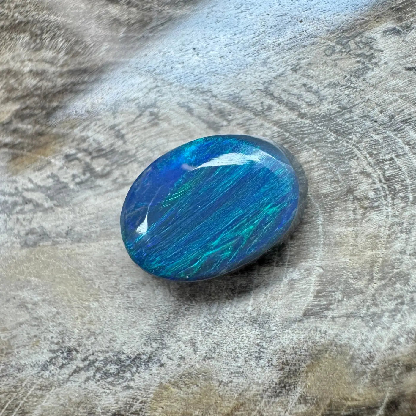 Oval-shaped blue and green opal displayed in 1.4ct Hand-Cut Solid Lightning Ridge Semi Black Opal