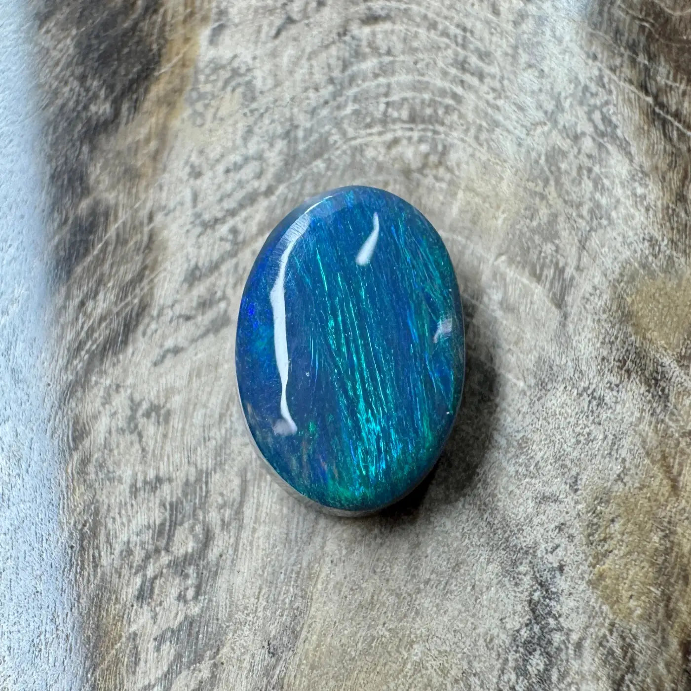 Oval-shaped blue and green opal from Lightning Ridge in a 1.4ct hand-cut semi Black Opal