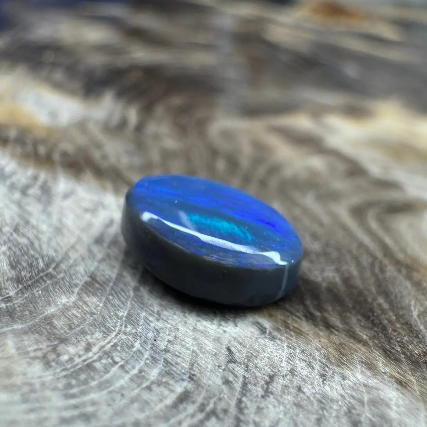 Oval-shaped blue opal with iridescent shimmer in a 1.4ct Hand-Cut Solid Lightning Ridge Semi Black Opal