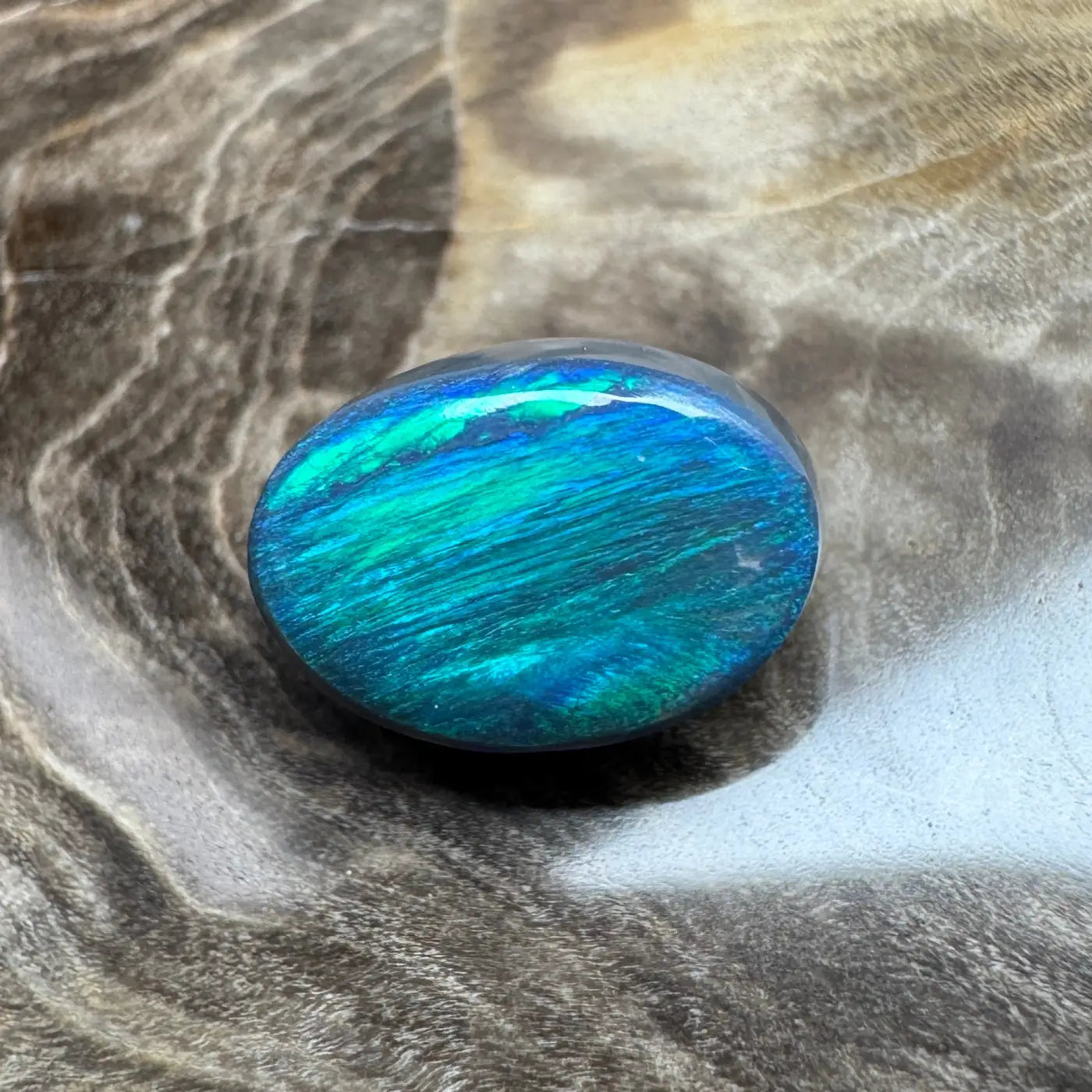 Polished blue-green opal cabochon from Lightning Ridge for jewelry crafting
