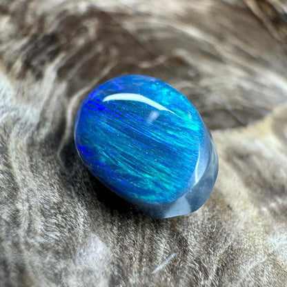 Polished blue opal cabochon showcasing vibrant coloration in the 1.4ct Hand-Cut Solid Lightning Ridge Semi Black Opal