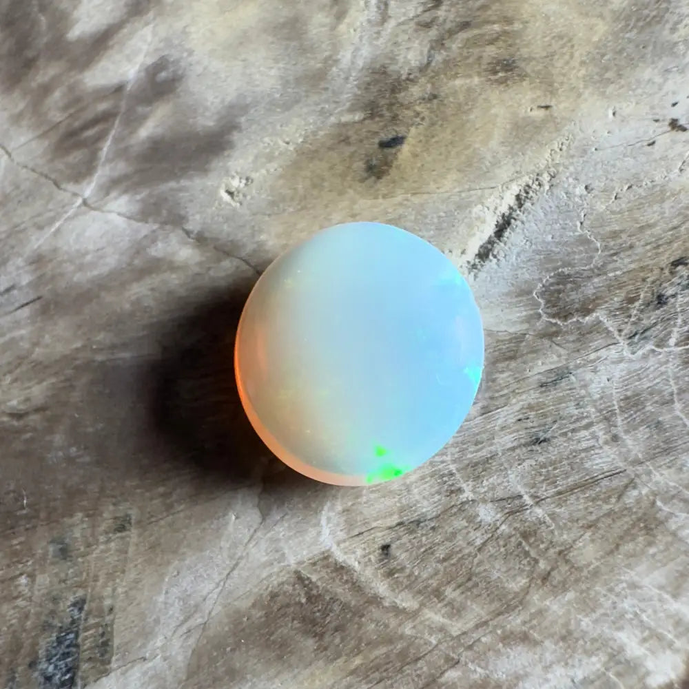 Round opal gemstone with iridescent colors.