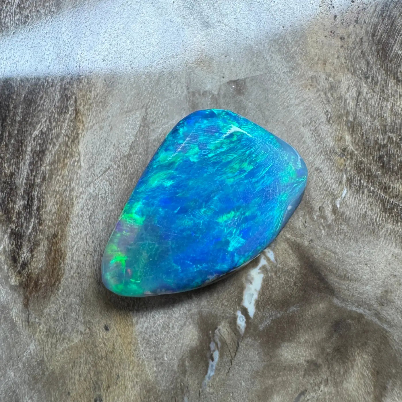 Iridescent blue-green opal from Lightning Ridge in a 1.8 carat hand-cut solid semi-black opal