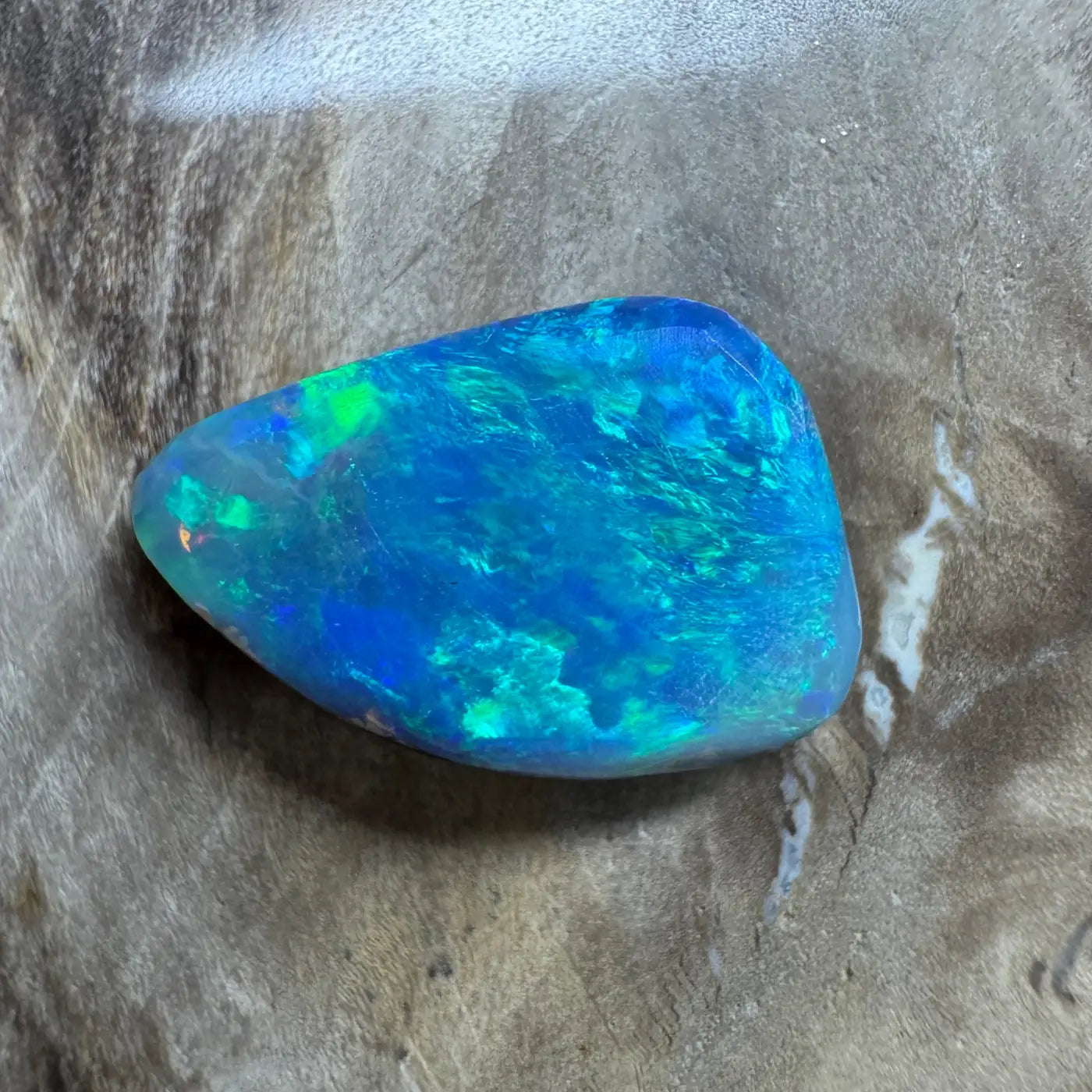 Iridescent blue-green opal gemstone from Lightning Ridge in a 1.8ct handcrafted semi-black opal