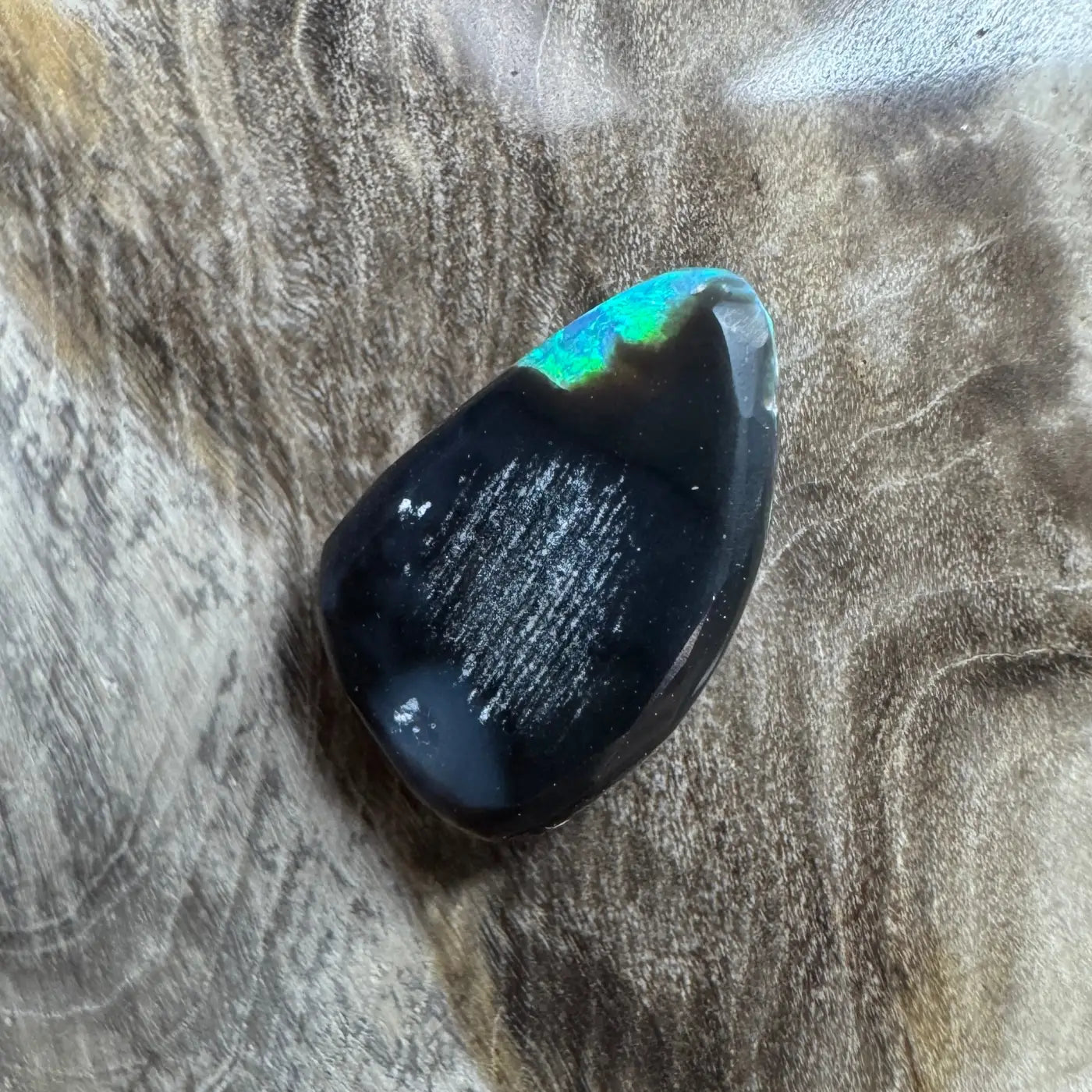 Polished black opal with iridescent green flash in 1.8ct Hand-Cut Lightning Ridge Semi Black Opal
