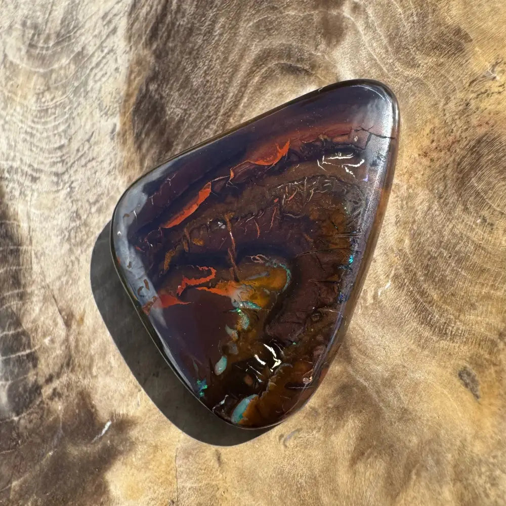 Polished dark opal cabochon.