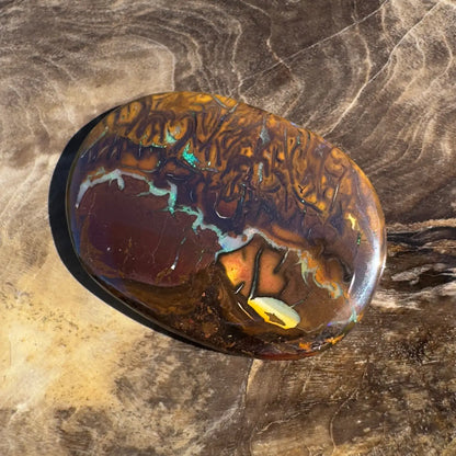 Polished brown Boulder Opal with iridescent flashes in a 15.9 carat hand-cut solid gemstone