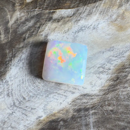 Square opal gemstone with iridescent colors.
