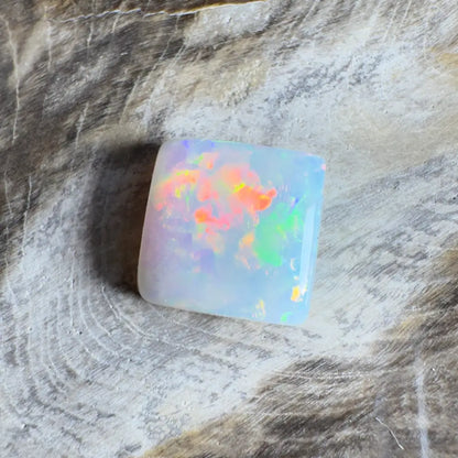 Square opal gemstone with vibrant color play.