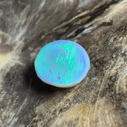 Iridescent blue-green opal cabochon.