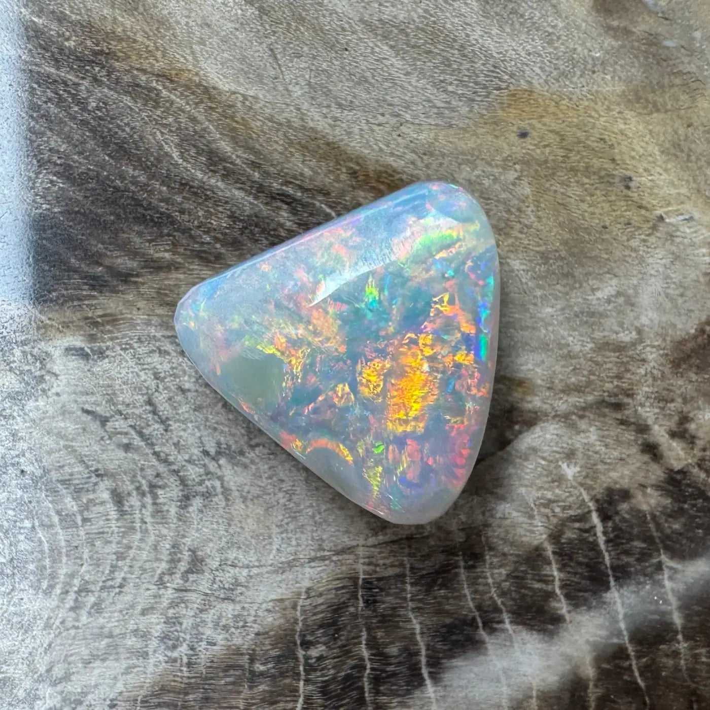 Iridescent triangular Lightning Ridge semi-black opal gemstone weighing 2.9 carats