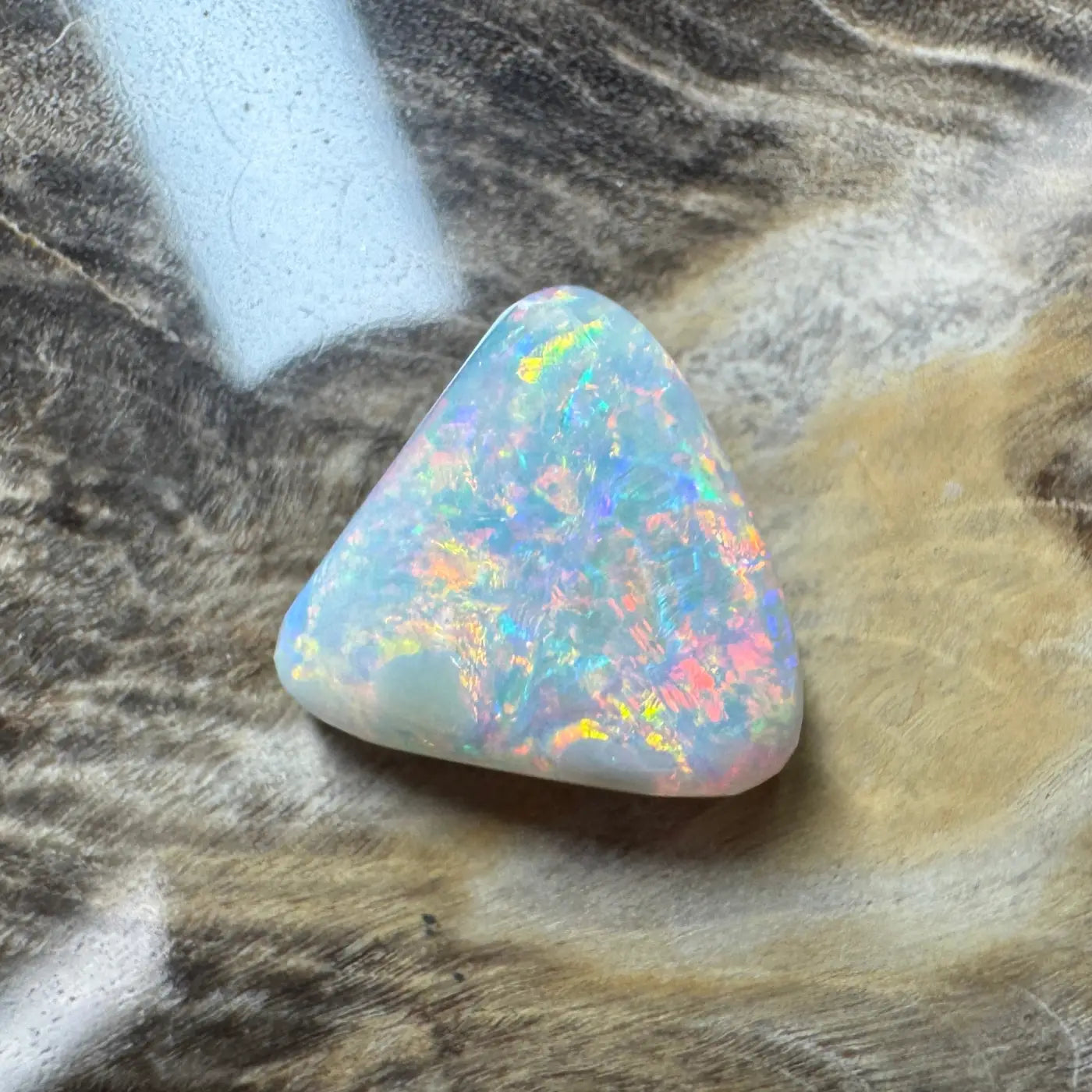 Iridescent triangular Lightning Ridge semi-black opal with vibrant play of colors