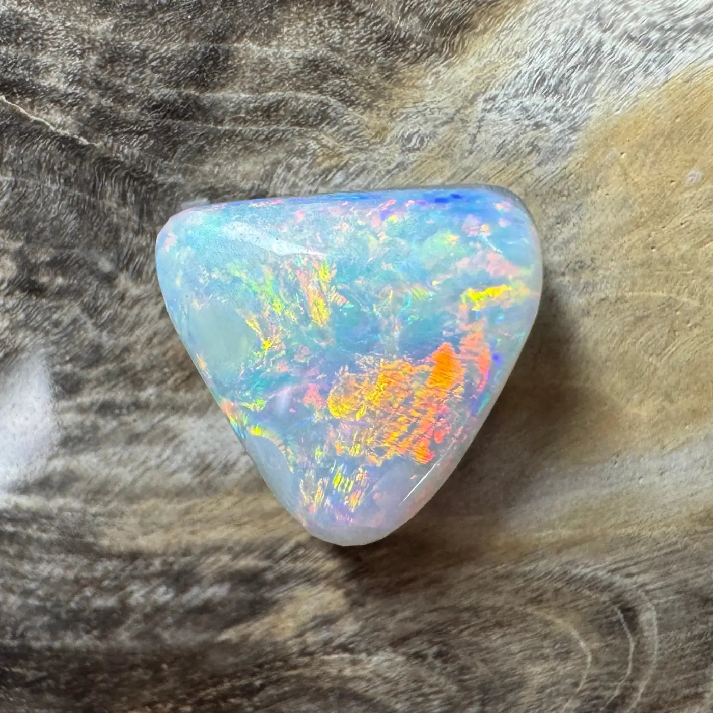 Iridescent triangular Lightning Ridge semi-black opal gemstone for jewelry or collection