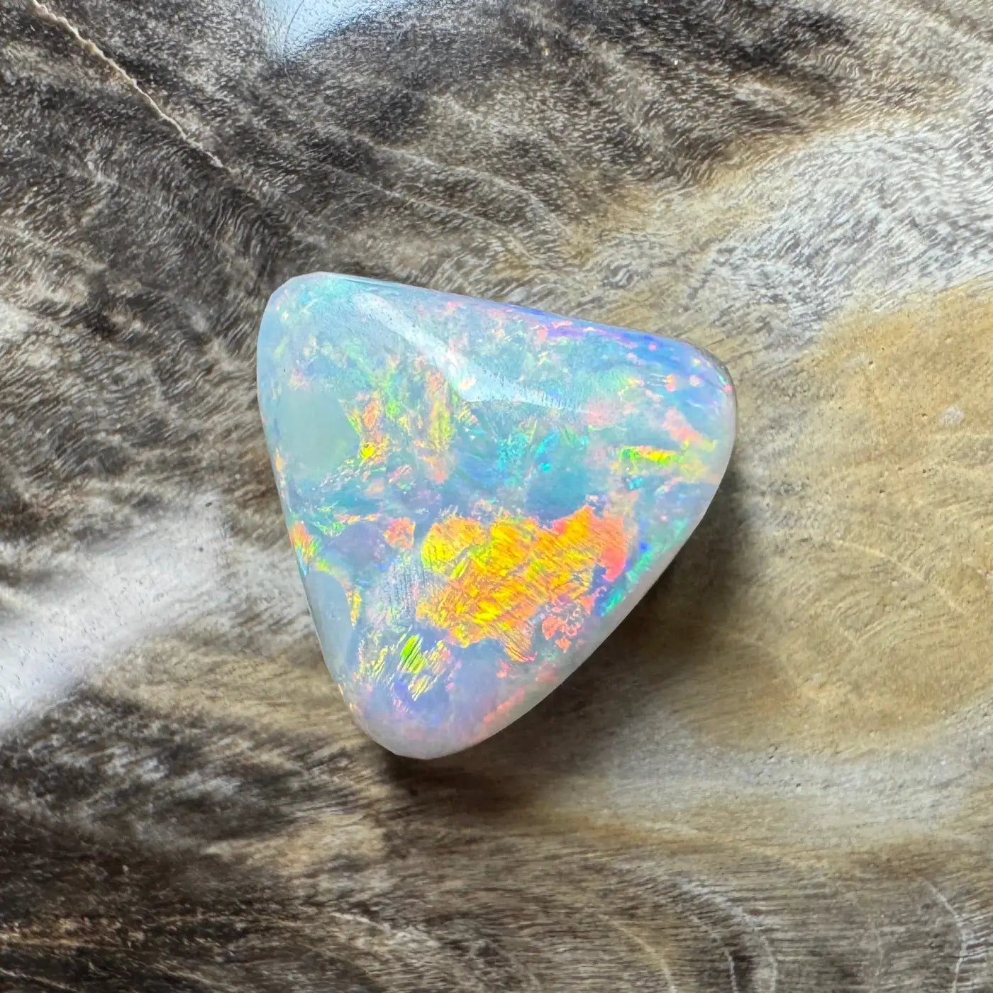 Iridescent triangular Lightning Ridge semi-black opal gemstone in a 2.9ct hand-cut design