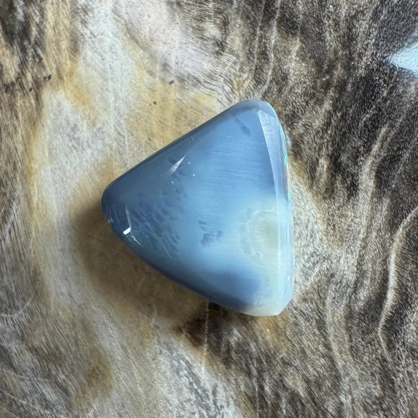 Polished blue-gray triangular Lightning Ridge semi black opal gemstone for jewelry