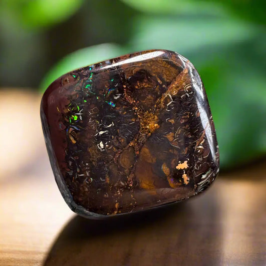 Polished dark Queensland Boulder Opal with iridescent flashes showcasing vibrant colors