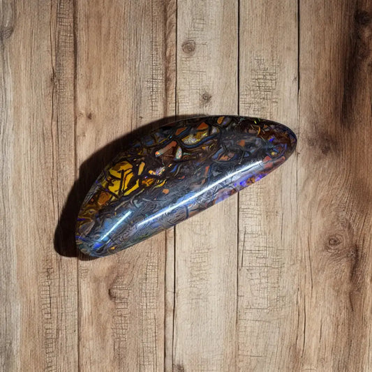 Polished multicolored Queensland Boulder Opal cabochon showcasing vibrant hues and intricate patterns