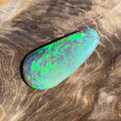 Iridescent green opal cabochon.