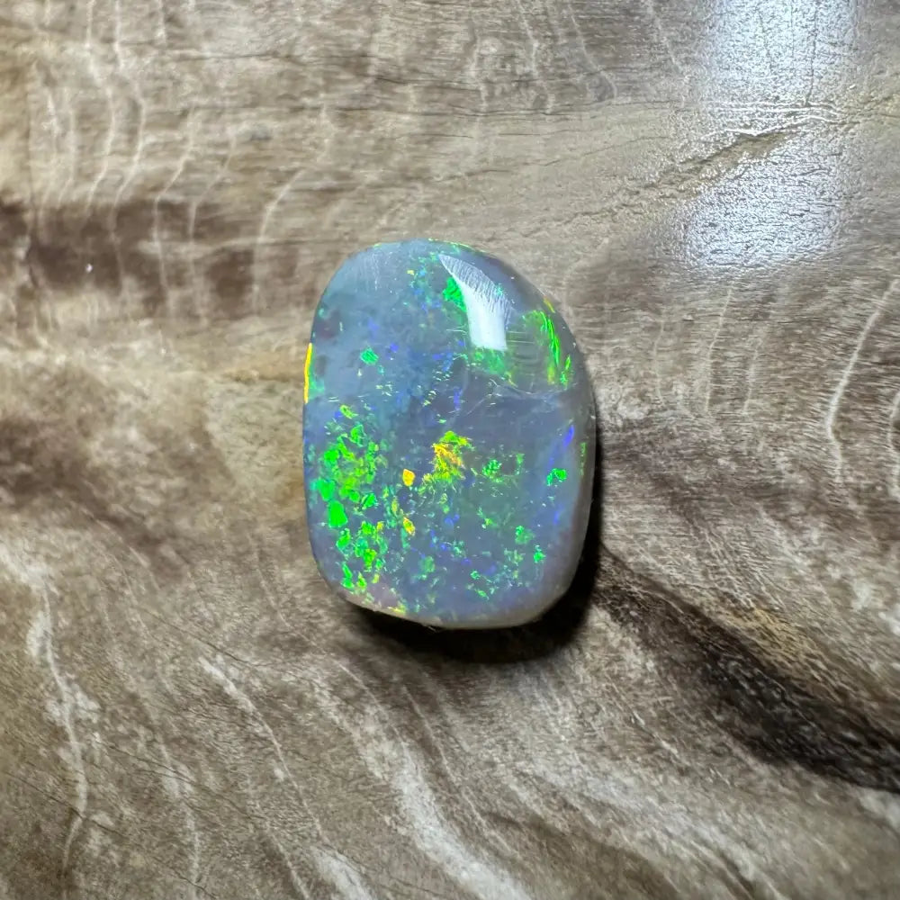 Polished Lightning Ridge semi black opal displaying vibrant green and yellow play-of-color