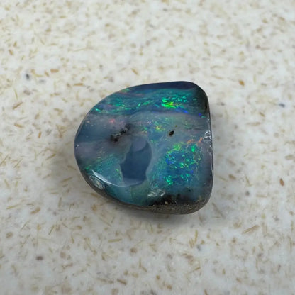 Iridescent Queensland Boulder Opal gemstone displayed in 5.9 carat hand-cut jewelry