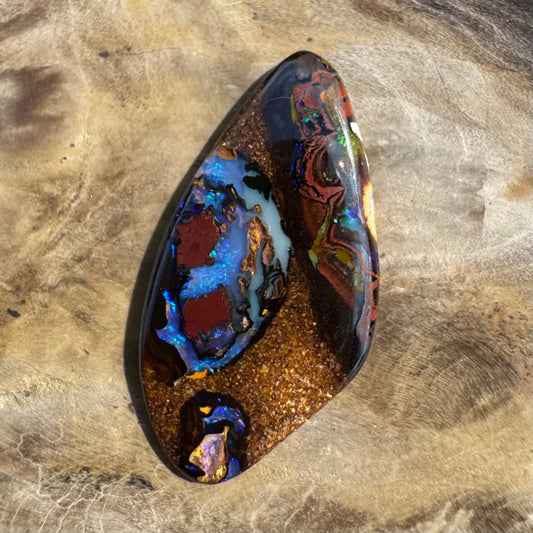 Polished 7.1ct Hand-cut Queensland Boulder Opal gemstone displaying vibrant color play