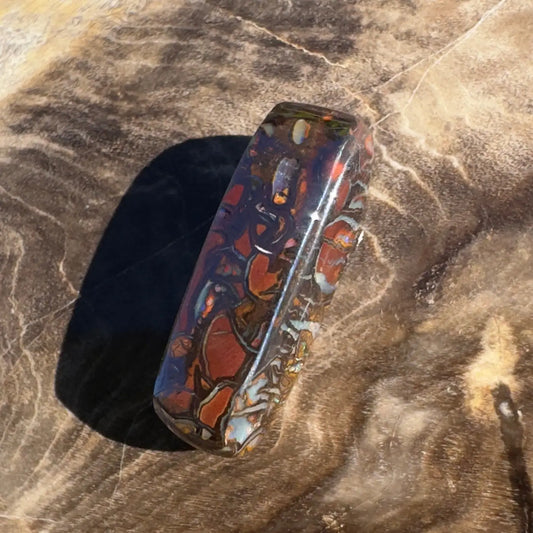 Polished rectangular Boulder Opal with red and black patterns in the 8.3ct Hand-Cut Solid Boulder Opal product