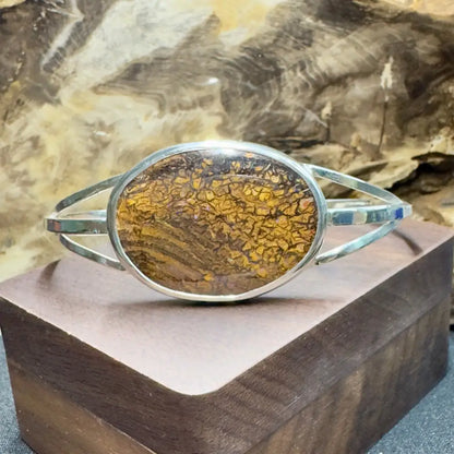 Silver bracelet with oval, brown and gold patterned stone.